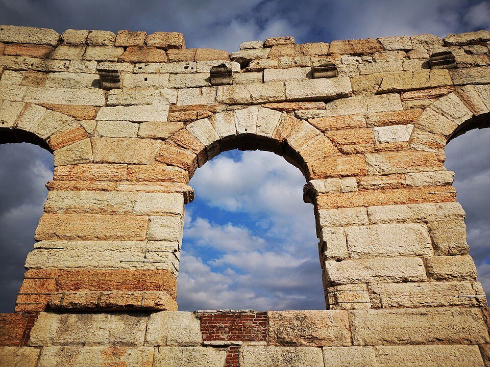 Blue sky through an arch of the Ala's pale limestone blocks