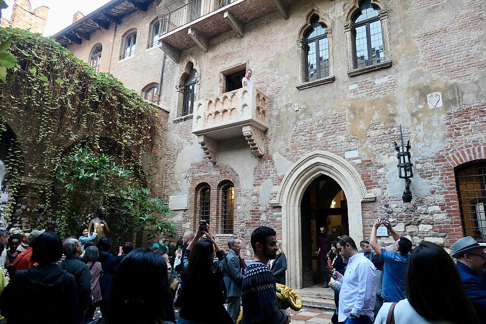 The crowded courtyard and the balcony above the doorway