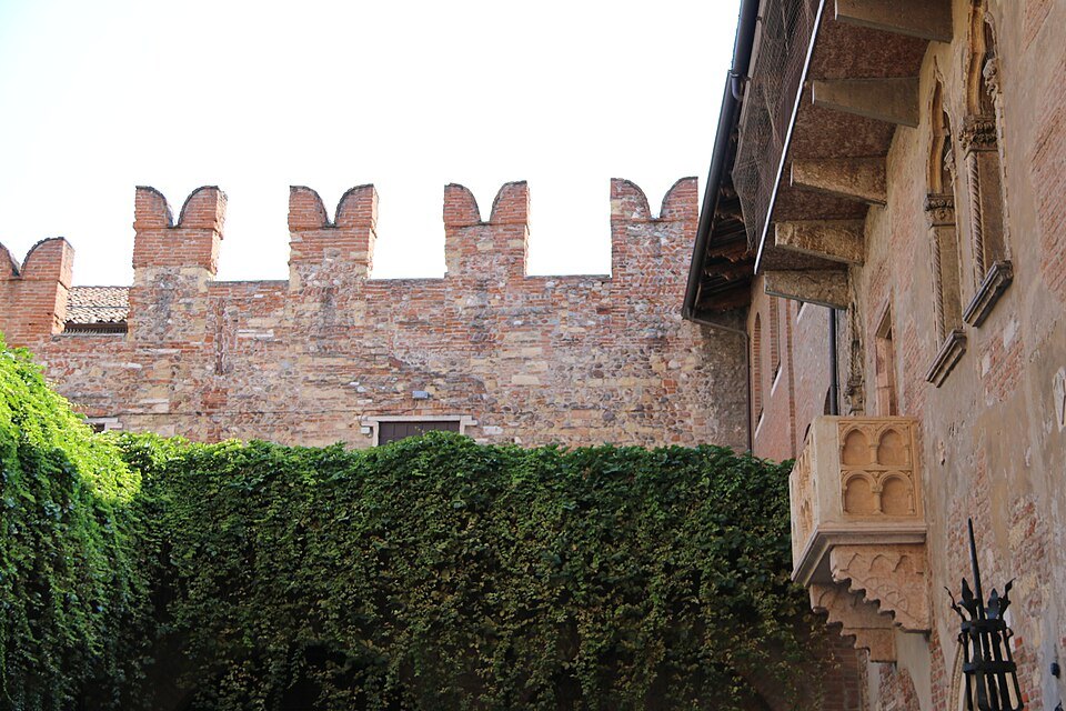 The courtyard's ivy wall and battlements, the balcony at the right