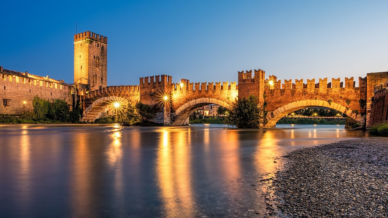 Castelvecchio and the Ponte Scaligero lit at dusk over the Adige