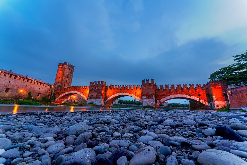 The Ponte Scaligero lit over the pebbles of the Adige
