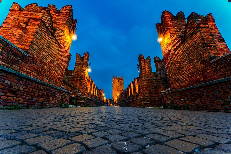 The bridge's merlons lit at the blue hour