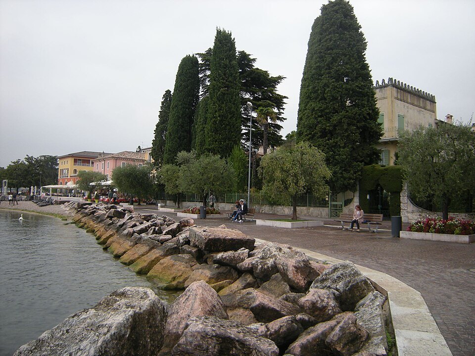 The rocky lake shore and cypresses at Cisano di Bardolino