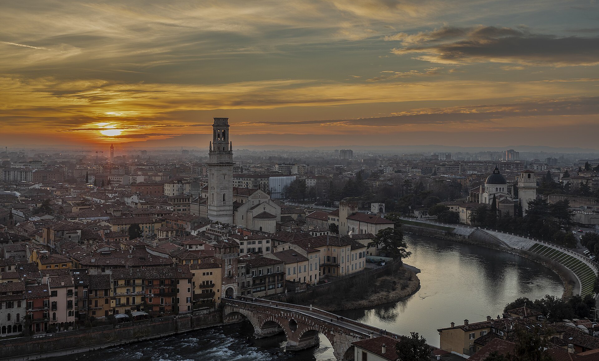 The sun setting over the Adige loop and the Duomo's bell tower, seen from Castel San Pietro