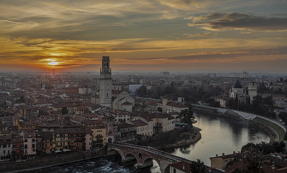 The sun setting over the Adige loop and the Duomo's bell tower, seen from Castel San Pietro