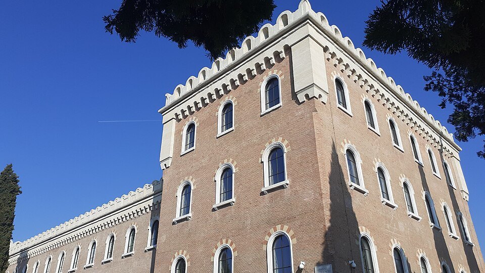 The Austrian barracks on the Castel San Pietro hill, battlemented roofline against blue sky