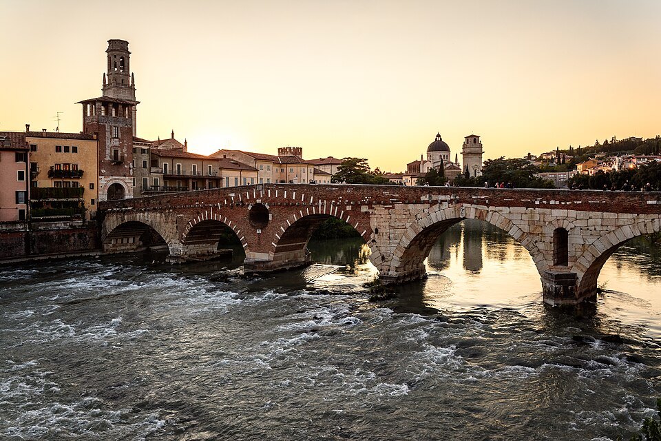 The Ponte Pietra in evening light, the Duomo tower behind