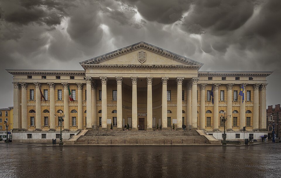 The columned front of Palazzo Barbieri, the town hall, under a stormy sky