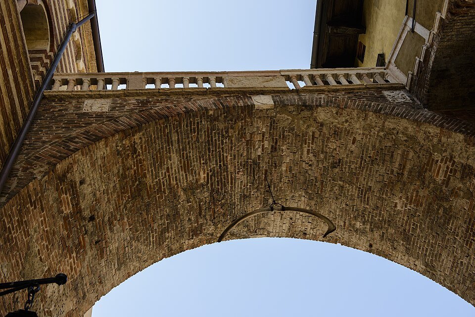 Looking up under the Arco della Costa between the two squares