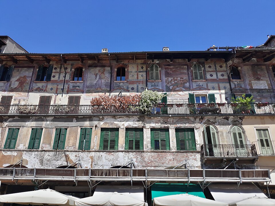 Faded frescoes and green shutters on the Case Mazzanti above the market