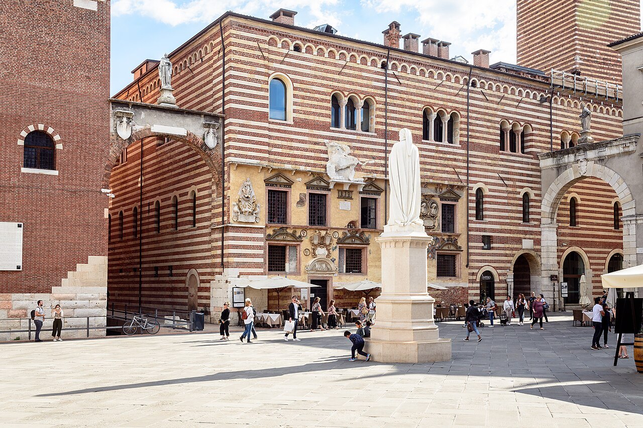 Dante's statue in Piazza dei Signori before the striped Palazzo della Ragione