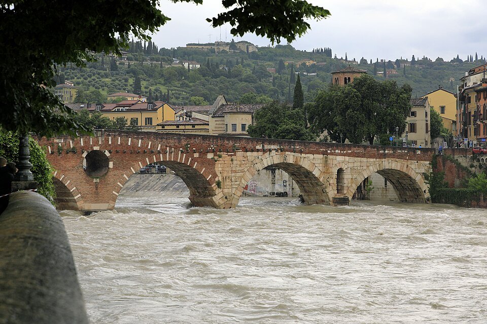 The Ponte Pietra over the high brown Adige