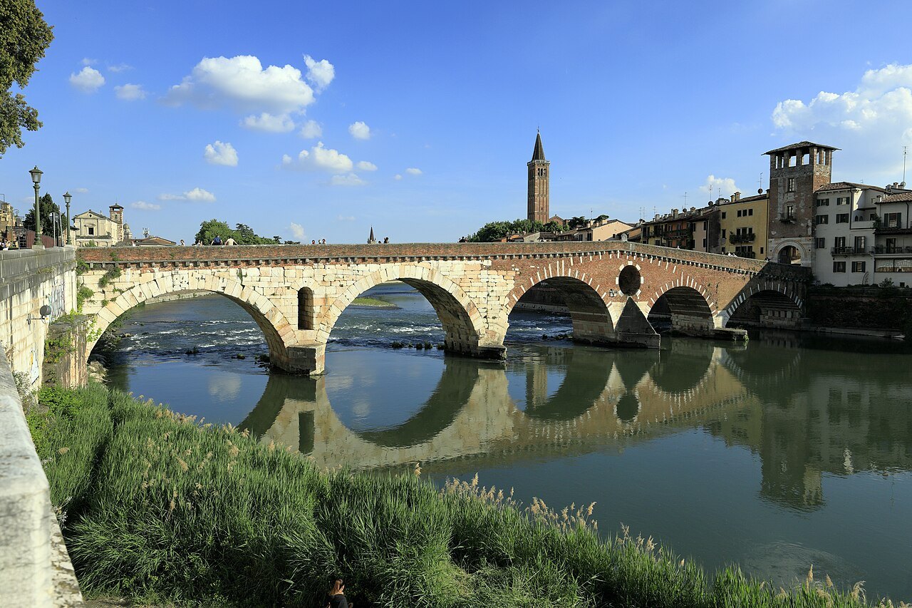 The Ponte Pietra's arches reflected in the Adige, the tower of Sant'Anastasia behind