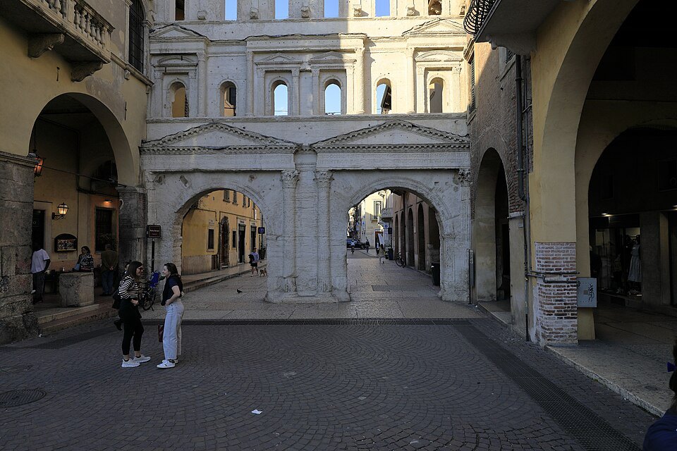Porta Borsari across the street, its upper windows open to the sky