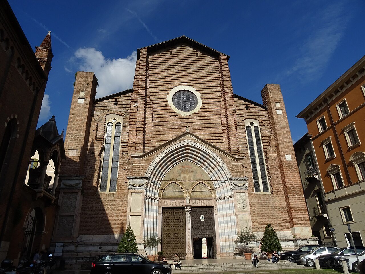 The brick front and portal of Sant'Anastasia under a blue sky